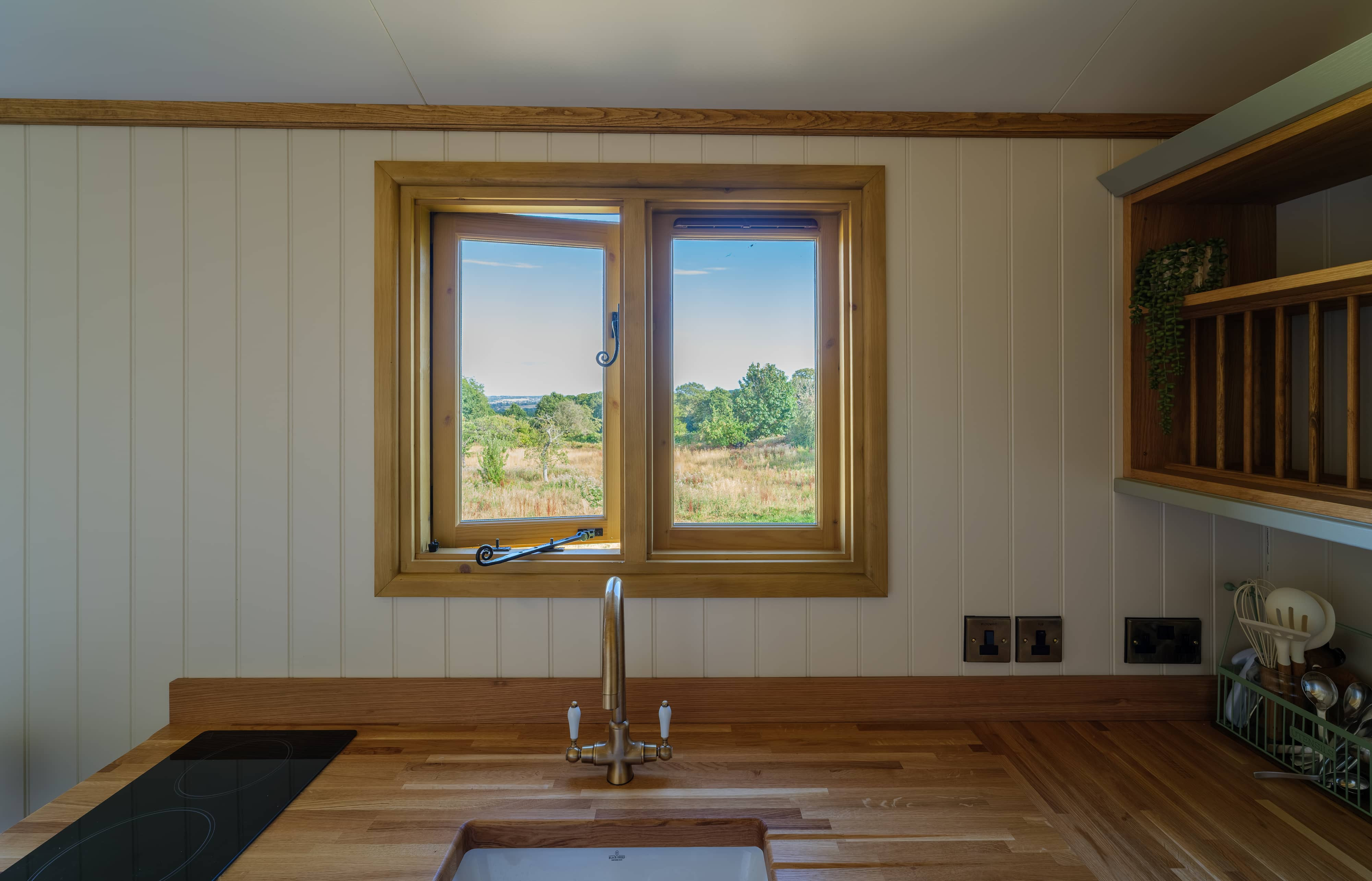 Close view of the kitchen sink facing out the window to the trees