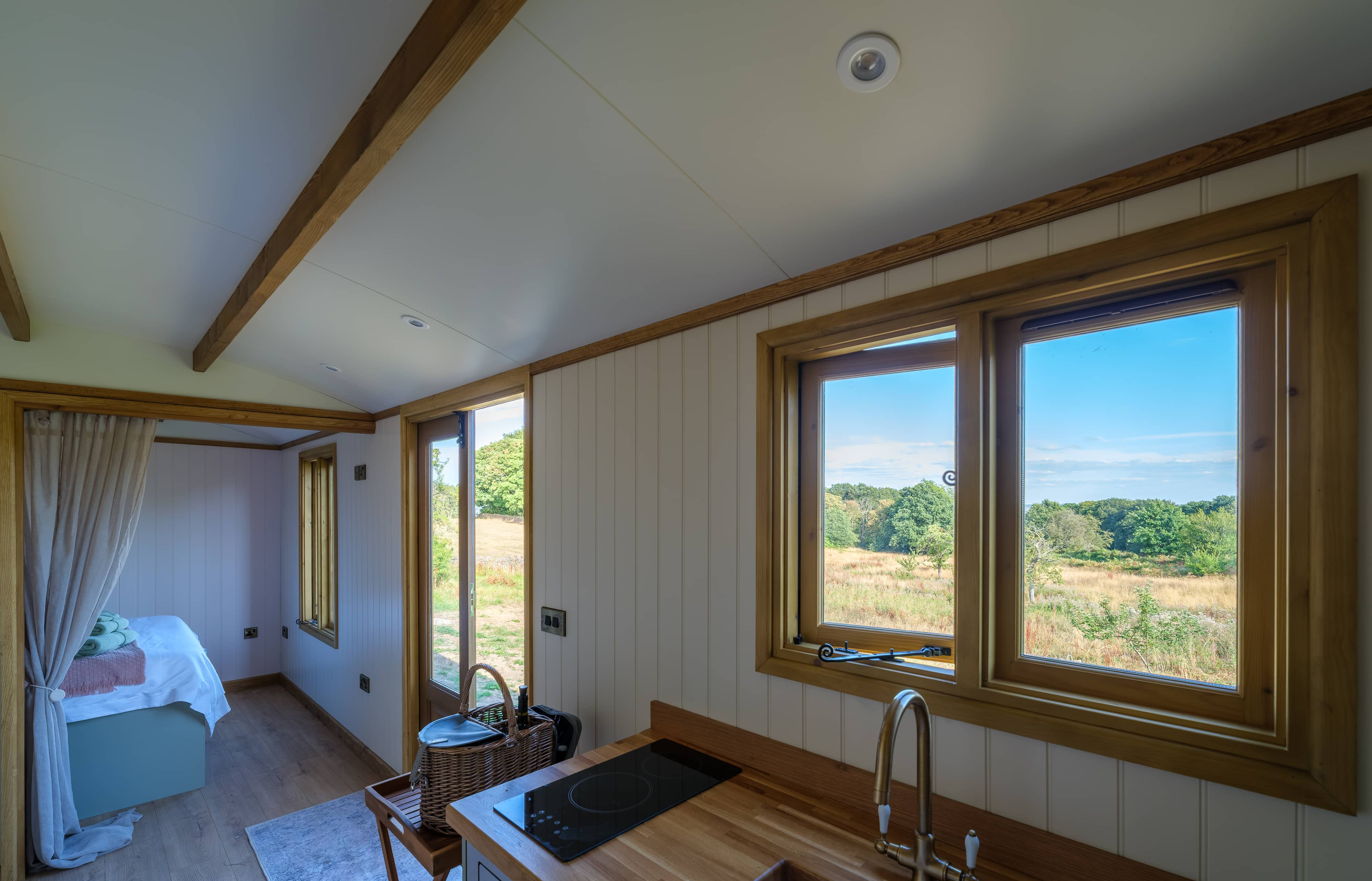 Interior showing sage green cabinets, warm oak wood countertops, and a Belfast sink